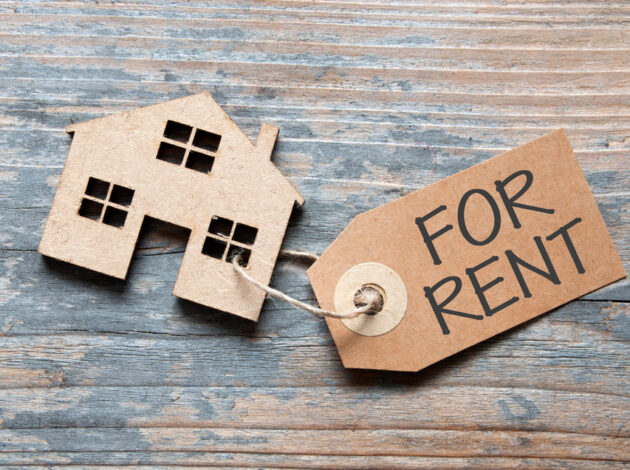 Image of a wooden model of a house with a "for Rent" ticket attached to it.